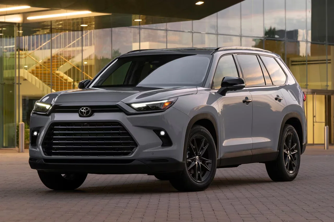 2025 Toyota Grand Highlander Hybrid parked in front of Toyota of Bristol dealership, highlighting its three-row size, bold styling, and hybrid badging.